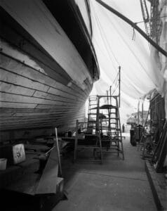 The starboard side of the Virginia V's hull with wide ladders pointing to where the caulking team left off.