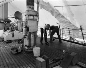 A team works on caulking the deck of the Lightship Swiftsure.