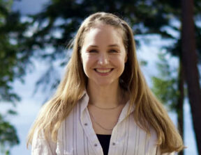 A photo of Jennifer Hess smiling at the camera, taken outside.
