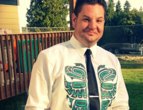 A photo of Ian Lawrence smiling at the camera, taken outside.